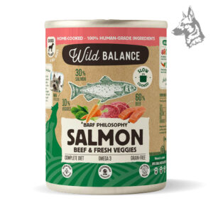 Lata de comida para perros Wild Balance BARF Philosophy con salmón y ternera, acompañada de ilustraciones de ingredientes naturales como pescado, carne y vegetales. Destaca su fórmula cocinada a fuego lento y sin cereales.