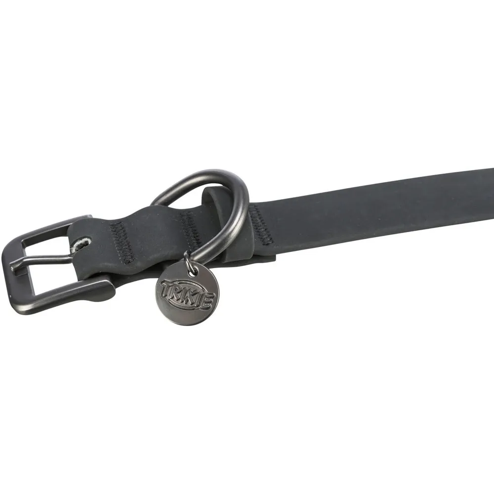 Primer plano del cierre del collar Trixie de PVC negro para perro, con hebilla metálica, anilla y chapa identificativa de la marca.