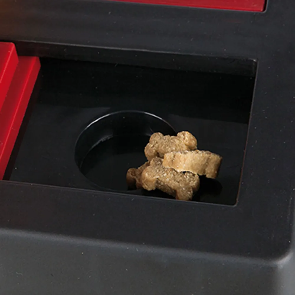 Primer plano del compartimento del Dog Activity Chess con snacks en forma de hueso para perros, parte del juego de inteligencia avanzado.