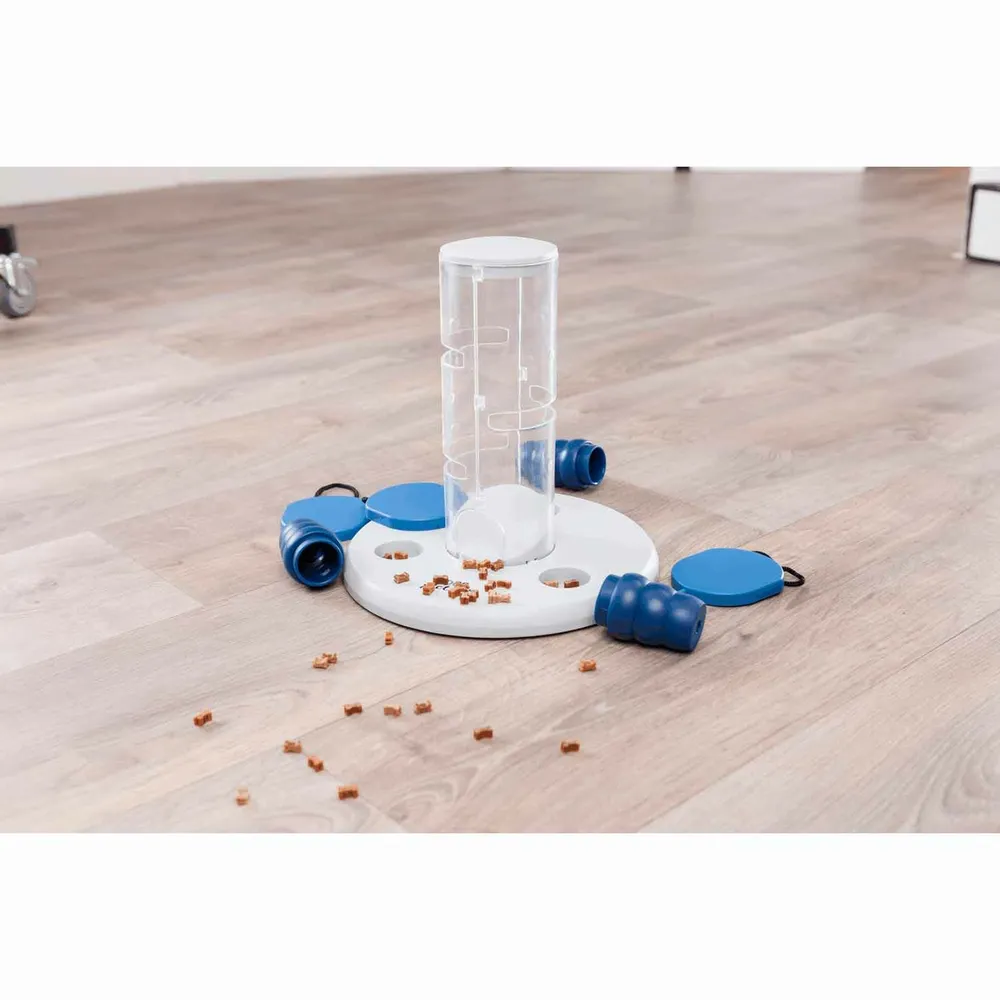 Juguete Dog Activity Gambling Tower tras su uso, con piezas desmontadas y premios esparcidos por el suelo, juego interactivo para perros.