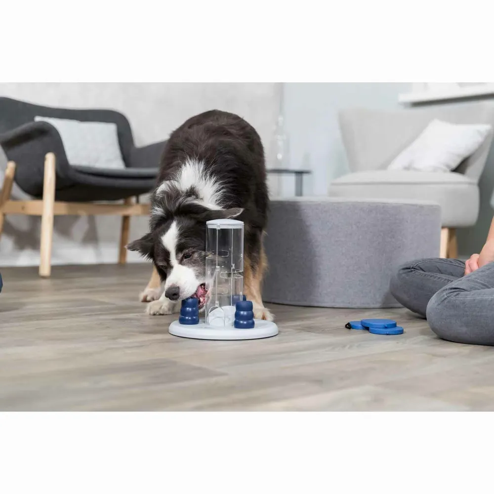 Perro interactuando con el juguete Dog Activity Gambling Tower en casa, resolviendo el juego de inteligencia para liberar premios.